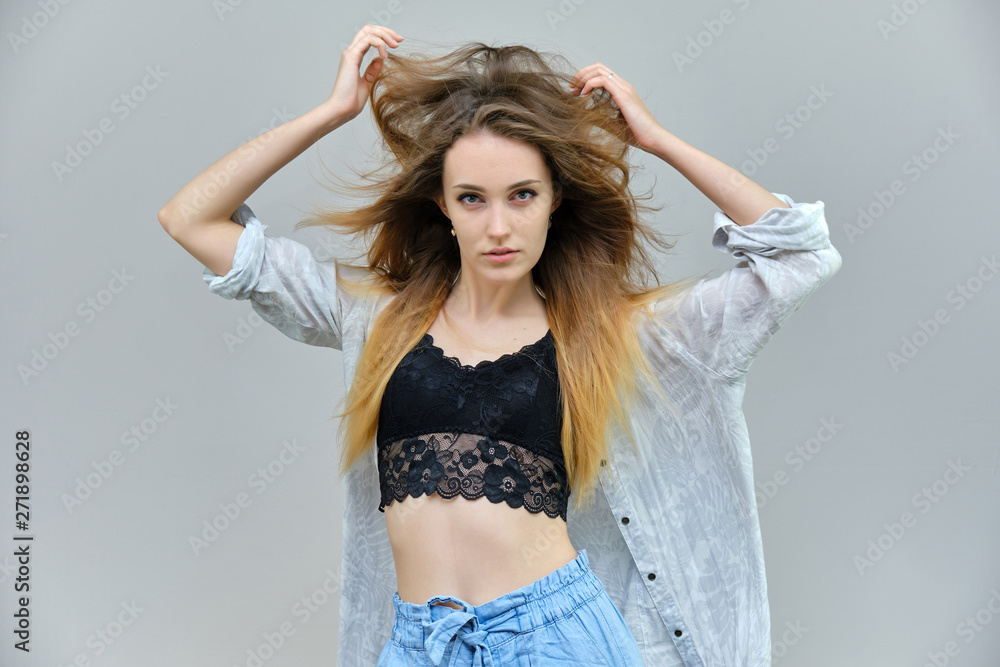 Photograph of a portrait of a beautiful girl woman with long dark flowing hair, satisfied life on a gray background. She stands in front of the camera in different poses with different emotions. Photograph of a portrait of a beautiful girl woman with long dark flowing hair, satisfied life on a gray background. She stands in front of the camera in different poses with different emotions.