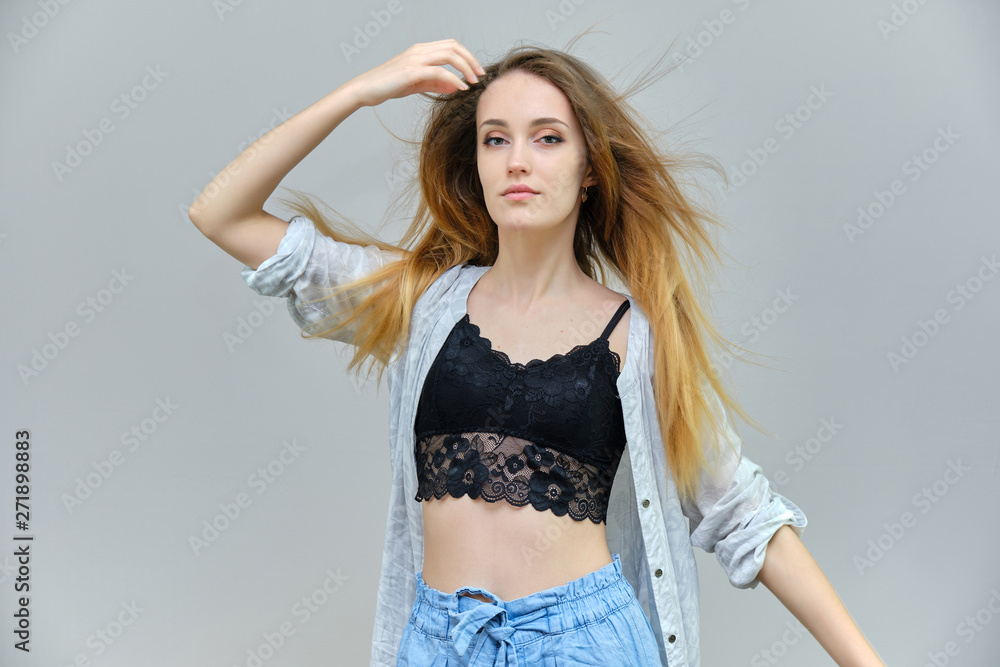 Photograph of a portrait of a beautiful girl woman with long dark flowing hair, satisfied life on a gray background. She stands in front of the camera in different poses with different emotions. Photograph of a portrait of a beautiful girl woman with long dark flowing hair, satisfied life on a gray background. She stands in front of the camera in different poses with different emotions.
