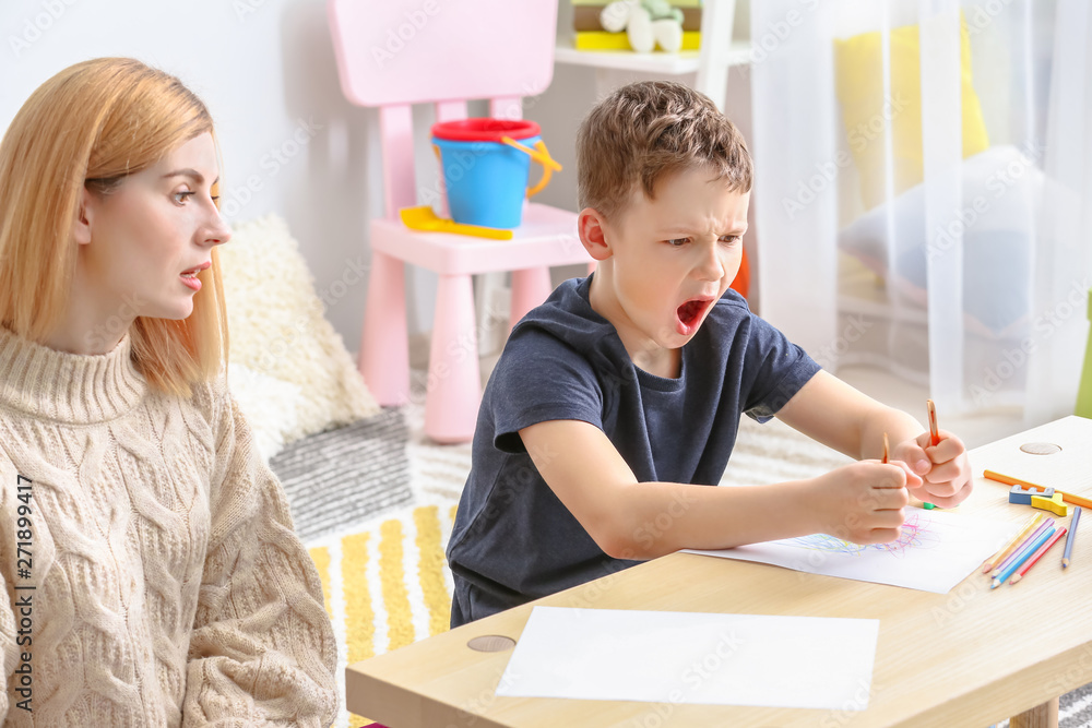 Female psychologist working with boy suffering from autistic disorder Female psychologist working with boy suffering from autistic disorder
