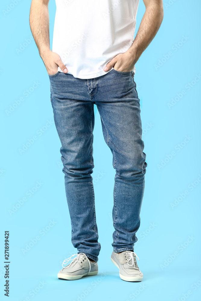 Stylish young man in jeans on color background Stylish young man in jeans on color background