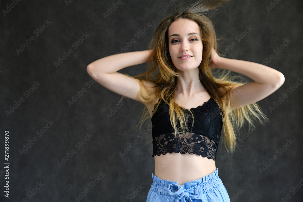 Photograph of a portrait of a beautiful girl woman with long dark flowing hair, happy life on a dark gray background. She is standing directly in front of the camera in various poses and smiling. Photograph of a portrait of a beautiful girl woman with long dark flowing hair, happy life on a dark gray background. She is standing directly in front of the camera in various poses and smiling.
