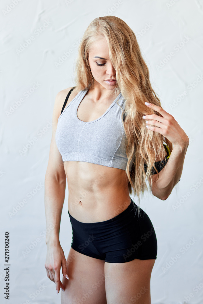Strong muscular girl in tight black shorts and white top looking down while  posing to the camera. sexuality , beauty concept. close up photo Stock  Photo | Adobe Stock