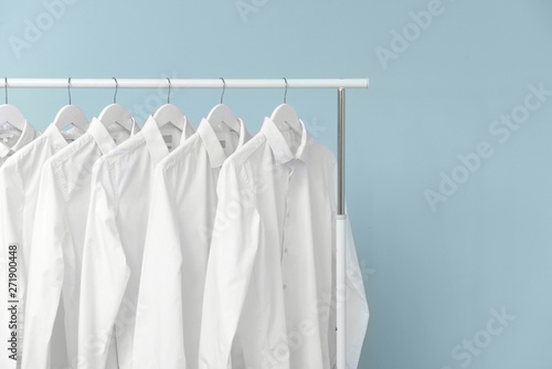 Rack with clothes after dry-cleaning on light background © Pixel-Shot