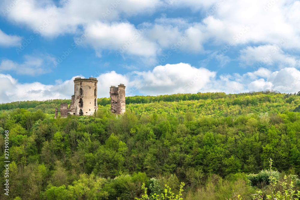 Ruined Chervonohrad Castle. Ruins of towers among the mountain forest