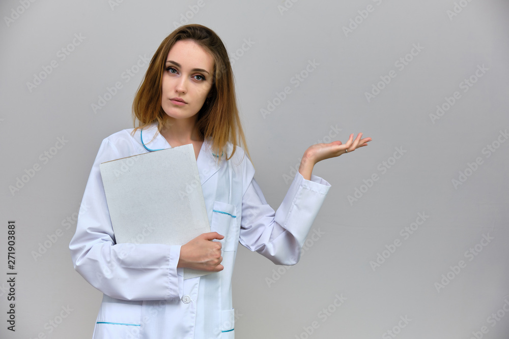 Photograph of a portrait of a beautiful girl doctor woman with long dark flowing hair, on a gray background with a folder in her hands. She is standing in different poses and smiling. Photograph of a portrait of a beautiful girl doctor woman with long dark flowing hair, on a gray background with a folder in her hands. She is standing in different poses and smiling.