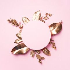 Golden leaves on pink background with copy space. Top view. Copy space. Summer and autumn concept. Creative design elements for invitation, wedding cards, valentines day, greeting cards.
