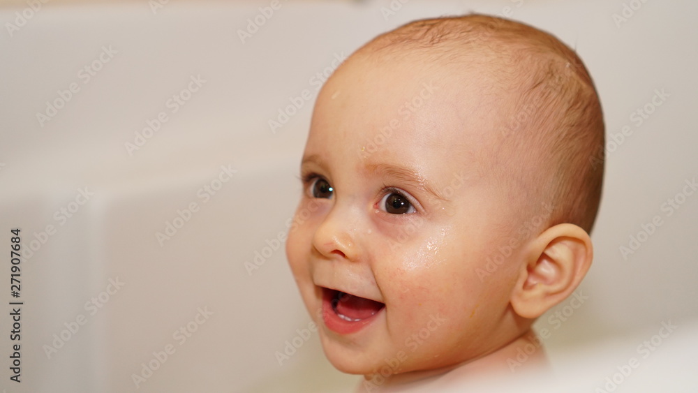Funny little child playing with water in a bathroom. Toddlers bathes. Funny little child playing with water in a bathroom. Toddlers bathes.
