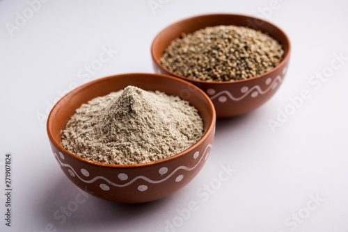 Bajra (pearl millet) / sorghum grains with it's flour or powder in a bowl, selective focus © Arundhati