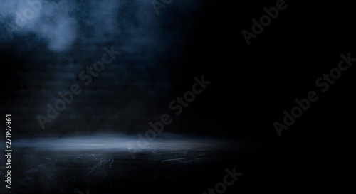 Dark empty scene, blue neon searchlight light, wet asphalt, smoke, night view, rays. Empty black studio room. Dark background. Abstract dark empty studio room texture. Product showcase spotlight back
