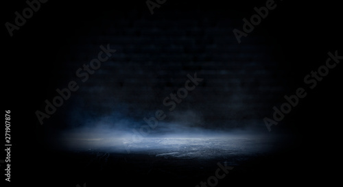 Dark empty scene, blue neon searchlight light, wet asphalt, smoke, night view, rays. Empty black studio room. Dark background. Abstract dark empty studio room texture. Product showcase spotlight back