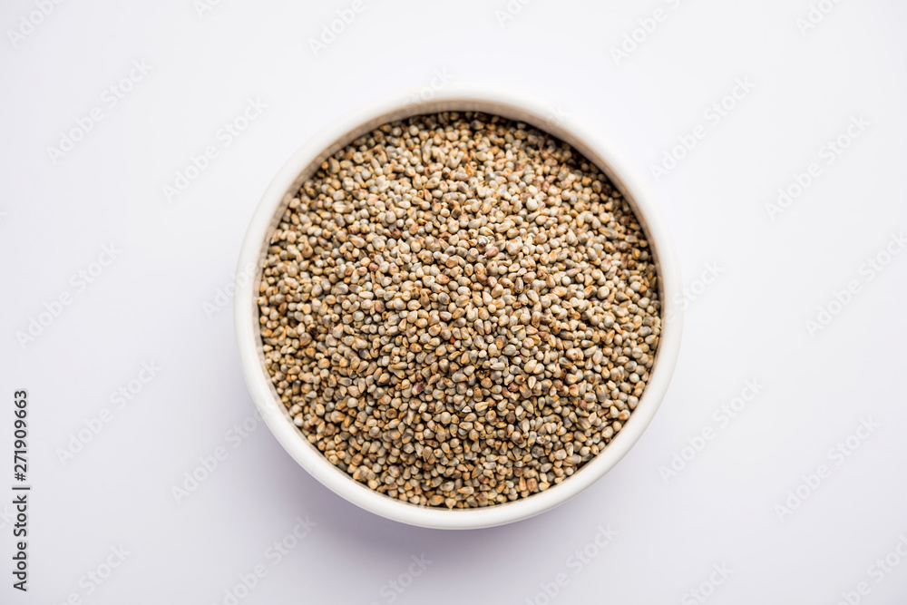 Bajra (pearl millet) / sorghum grains with it's flour or powder in a bowl, selective focus Bajra (pearl millet) / sorghum grains with it's flour or powder in a bowl, selective focus