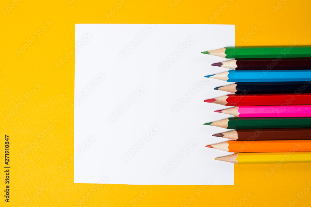 White square and color pencils on a yellow background. Notes for creativity and creative ideas. Empty space for text White square and color pencils on a yellow background. Notes for creativity and creative ideas. Empty space for text