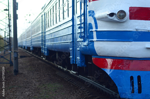 Old soviet electric train with outdated design moving by rail photo