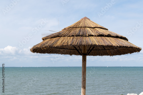 straw umbrella in the blue sky concept of holidays vacation