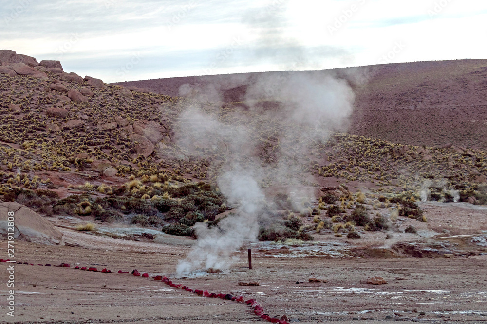 Fototapeta premium Hot spring at El Tatio Geysers with steaming geysers, hot springs, boiling water all around at sunrise, Chile, South America