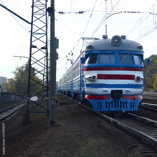 Old soviet electric train with outdated design moving by rail photo