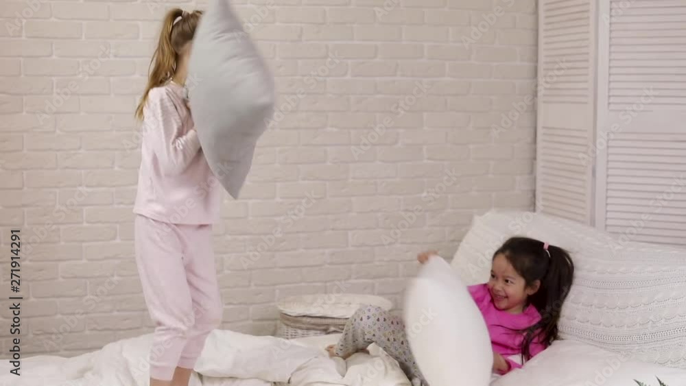 two cute children girls playing in the bedroom. pajama party and friendship. two cute children girls playing in the bedroom. pajama party and friendship.
