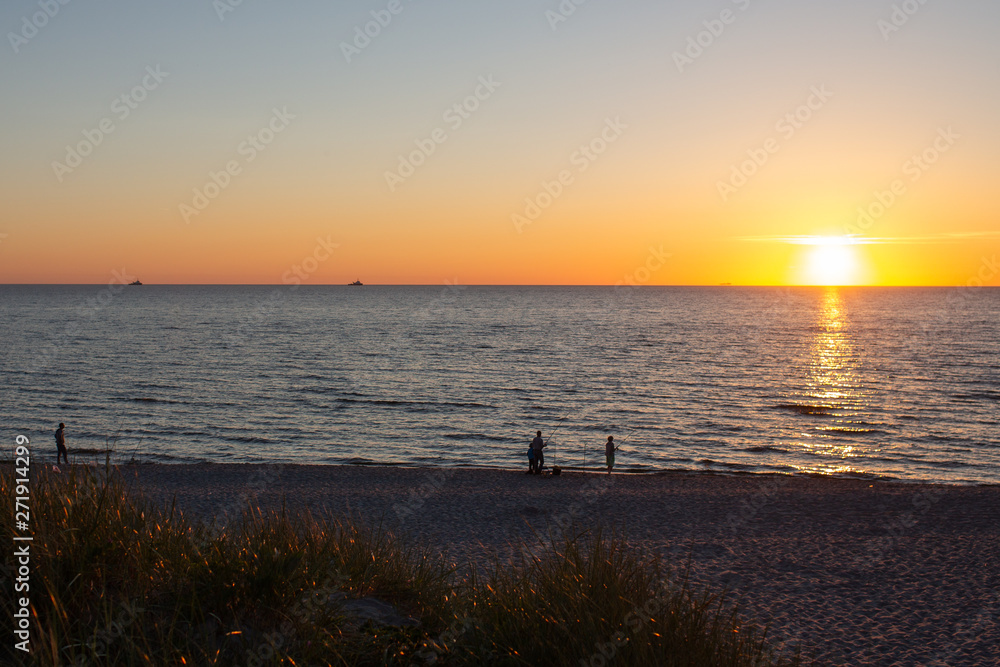 Sunset on the Baltic Sea. Fishermen catch fish.