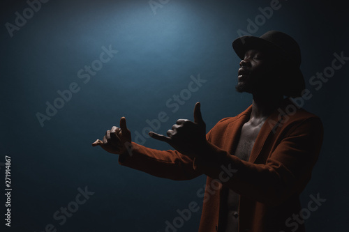 Φωτογραφία Portrait of male singer in hat and coat. Artist, performer