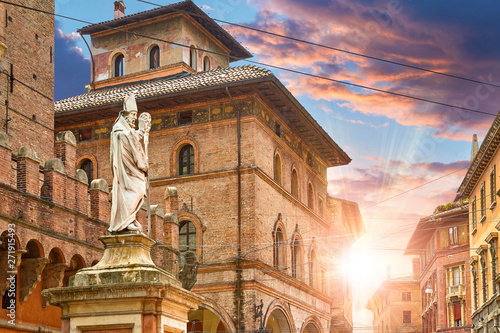 Bologna, Italy. Statue of San Pietro on Piazza di Porta Ravegnana. Evening Sunset among terracotta buildings in old town. photo