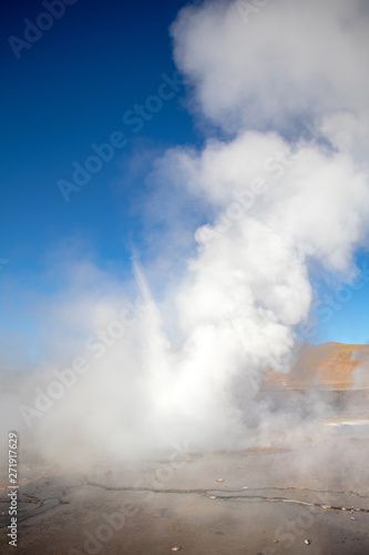 Erupting Hot Geyser Of Steam in El Tatio Geysers field at early morning sunrise, Atacama desert, Chile