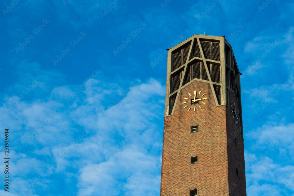 Kirchturm in Köln vor blauem Himmel