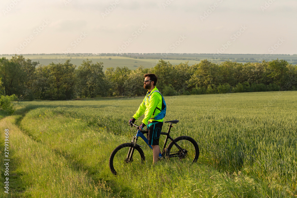 The cyclist rides on mtb. Freerider rides off-road through a wheat field. Athlete in training. Aggressive sports. Extreme recreation. The cyclist rides on mtb. Freerider rides off-road through a wheat field. Athlete in training. Aggressive sports. Extreme recreation.