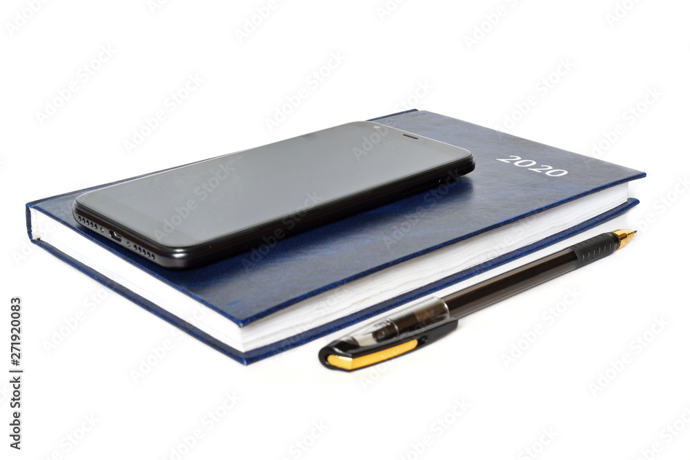 Closed blue leather notebook for new year with text 2020 on cover, ballpoint pen and black classic modern smartphone of front side on white background. Isolated Closed blue leather notebook for new year with text 2020 on cover, ballpoint pen and black classic modern smartphone of front side on white background. Isolated