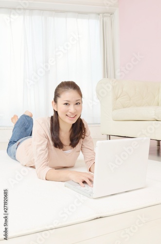 寝転んでパソコンを見る女性