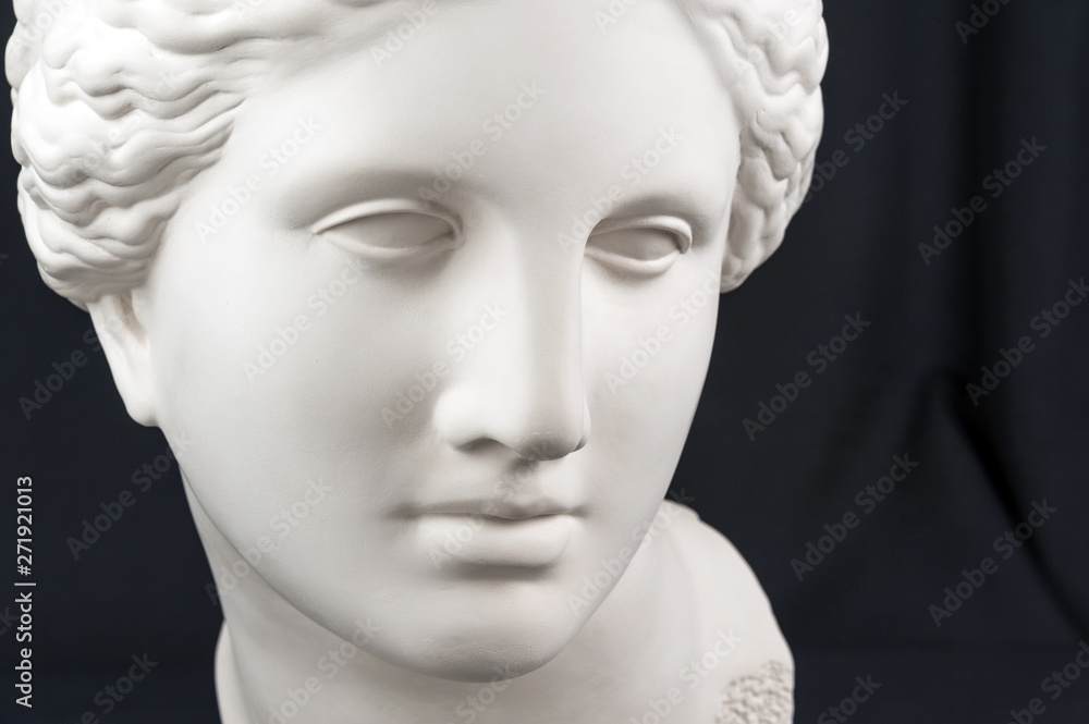 White gypsum copy of ancient statue Venus head on a black background. Plaster sculpture woman face. White gypsum copy of ancient statue Venus head on a black background. Plaster sculpture woman face.