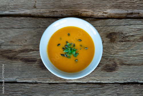 Pumpkin soup puree on wood deck.
