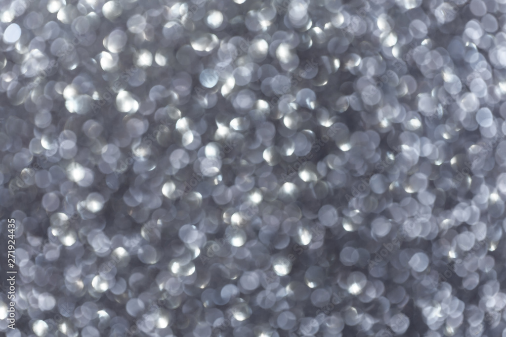 Blurred shiny silver background with sparkling lights.