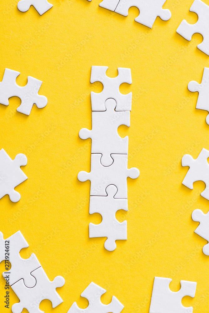 Obraz premium top view of connected white puzzle pieces isolated on yellow