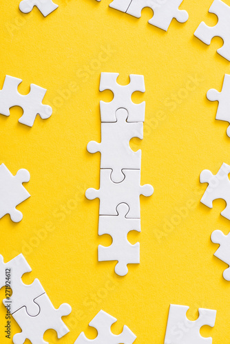 top view of connected white puzzle pieces isolated on yellow