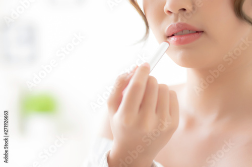 Beautiful closeup young asian woman applying makeup lipstick in the room  beauty lips asia girl makeup and cosmetic fashion on mouth at home  lifestyle and health care concept.