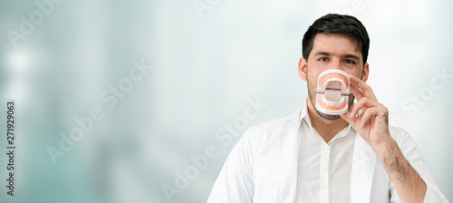 Young male dentist working in dental clinic. Dentistry care and medical service concept. photo