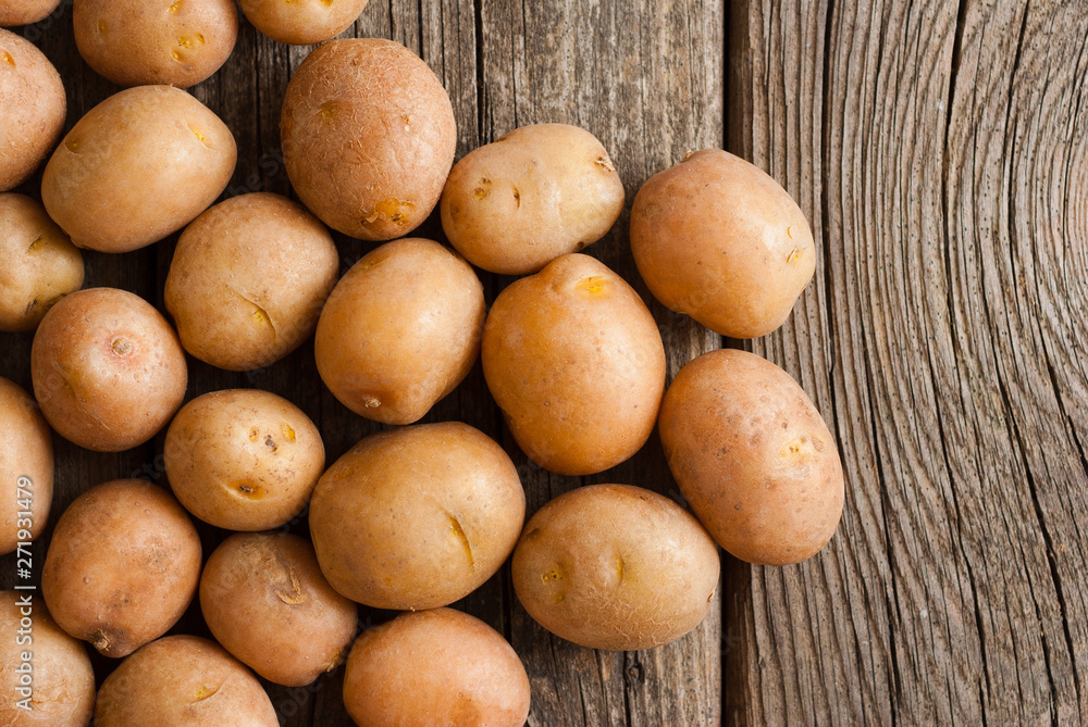 petite potatoes on rustic wood table background petite potatoes on rustic wood table background