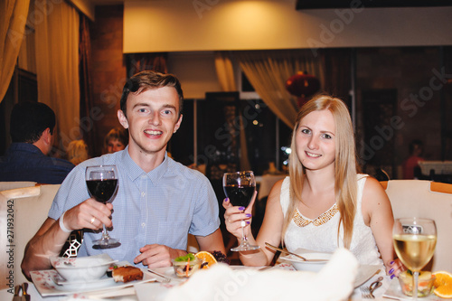 Beautiful young Man and happy woman sitting at a table in a restaurant and holding a glass of wine. Romantic evening. Vacation. celebration. Love. Turkey. Vacation. Night. close up. Honeymoon