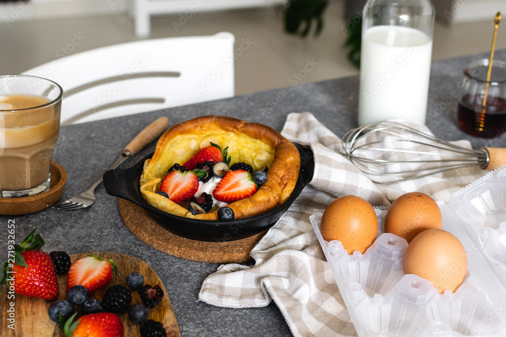 Dutch baby pancake with fresh berries, cup of cappuccino Dutch baby pancake with fresh berries, cup of cappuccino