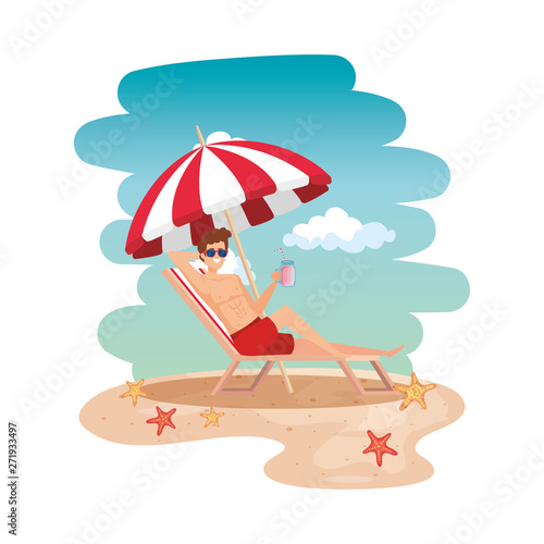 young man relaxing in beach chair drinking juice fruit on the beach