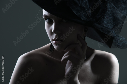 high fashion portrait of elegant woman in black and white hat and dress.