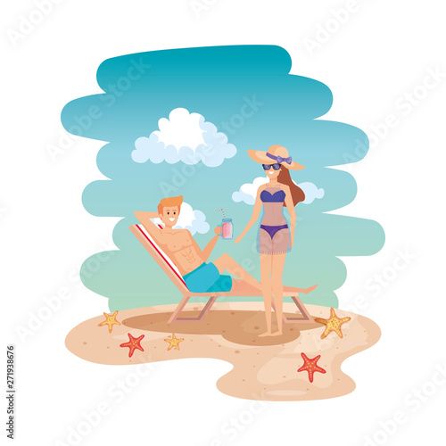young couple relaxing in chair drinking juice on the beach