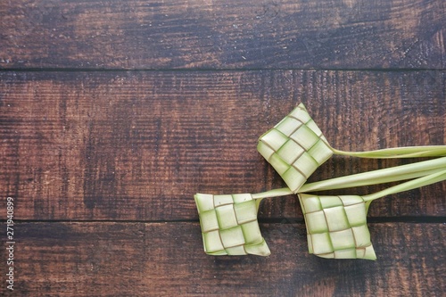 Ketupat (Rice Dumpling) On Wooden Background. Ketupat is a natural rice casing made from young coconut leaves for cooking rice during eid Mubarak, Fitri 