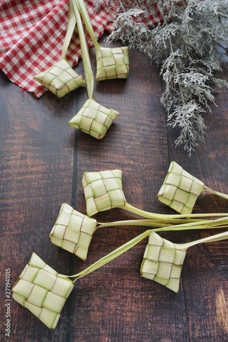 Ketupat (Rice Dumpling) On Wooden Background. Ketupat is a natural rice casing made from young coconut leaves for cooking rice during eid Mubarak, Fitri 