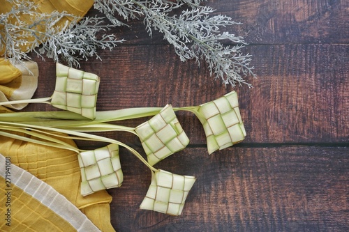 Ketupat (Rice Dumpling) On Wooden Background. Ketupat is a natural rice casing made from young coconut leaves for cooking rice during eid Mubarak, Fitri 