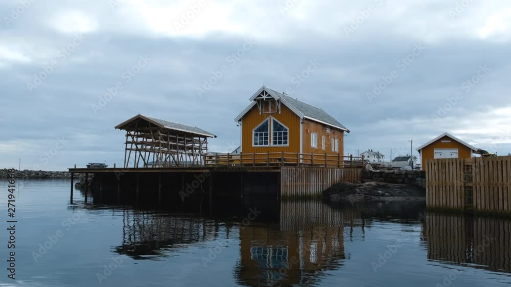 Yellow wooden rorbu house in fjord in Nusfjord, one of the oldest fisherman village in Norway. Lofoten islands, Norway Yellow wooden rorbu house in fjord in Nusfjord, one of the oldest fisherman village in Norway. Lofoten islands, Norway