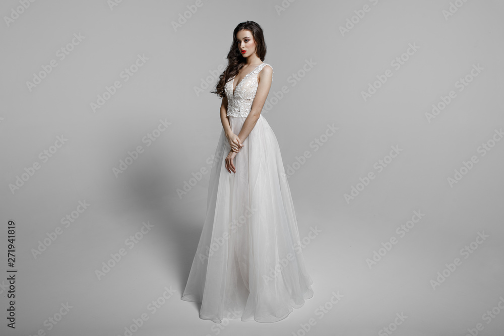 Young woman in beautiful dress sitting in studio. Attractive caucasian model, isolated on a white background. Young woman in beautiful dress sitting in studio. Attractive caucasian model, isolated on a white background.