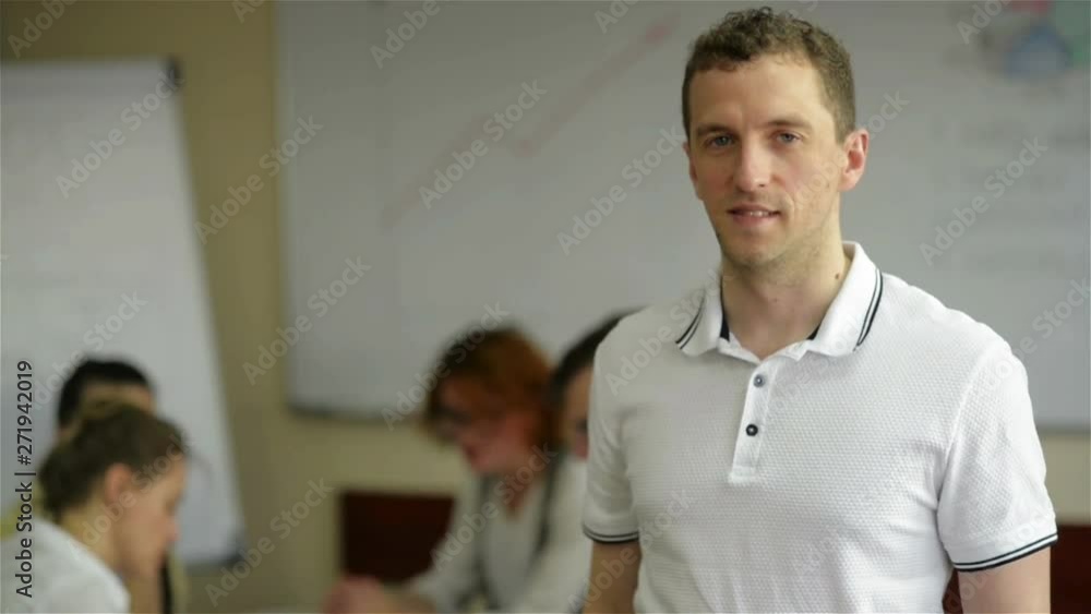 Smiling smart business man with team mates discussing in the background Smiling smart business man with team mates discussing in the background