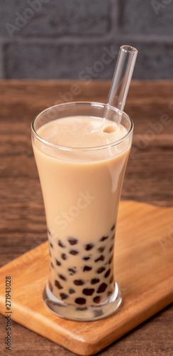 Delicious bubble milk tea with straw in drinking glass on wooden table background, concept of reduce plastic to go in Taiwan, close up, copy space