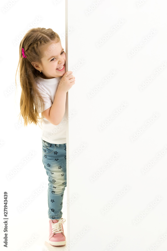 A little girl is looking from behind an empty banner. A little girl is looking from behind an empty banner.